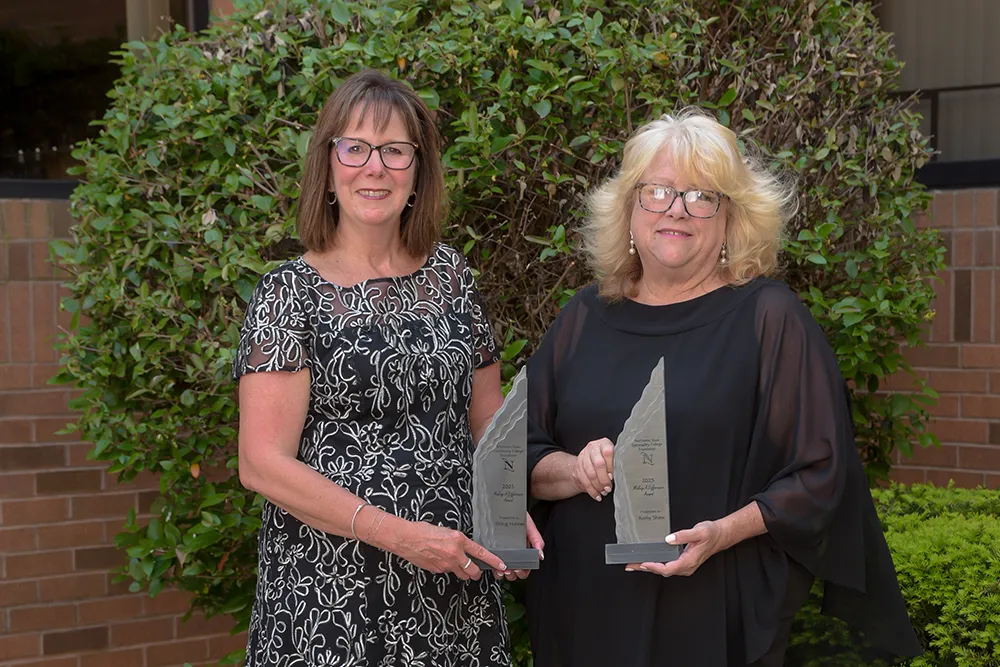 two women holding awards